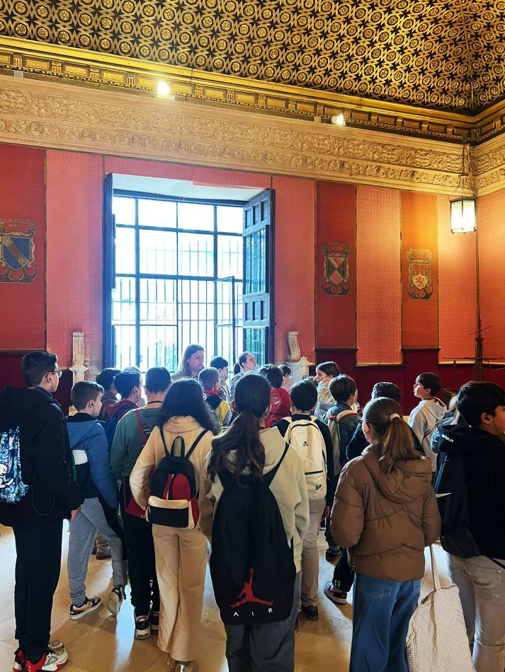 Visita escolar guiada en el Alcázar de Sevilla con estudiantes atentos a la explicación - foto de nuestras visitas guiadas